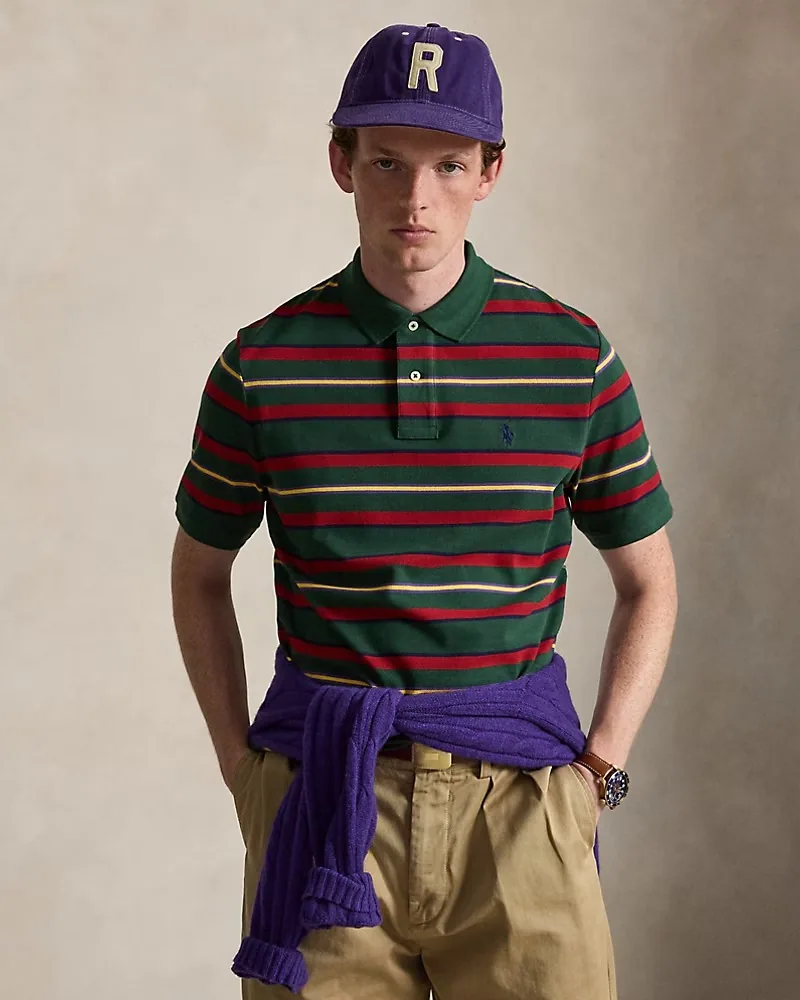 Modelo con camiseta polo a rayas verde y roja y gorra morada
